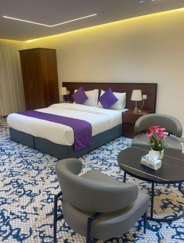 une chambre d'hôtel avec un lit, une table et des chaises dans l'établissement سفانة هلا للشقق المخدومة, à Hafr Al Baten