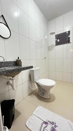 un bagno bianco con un water e un lavandino di Casa aconchegante e familiar a Barreirinhas