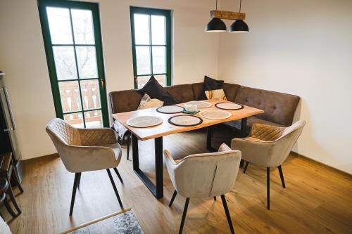 a dining room table with chairs and a couch at Vinařská búda nad golfem in Skalica