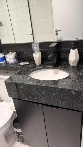 a bathroom with a sink and a toilet at Studio 107 Home Com Varanda, Ar-condicionado e Netflix in Mogi das Cruzes
