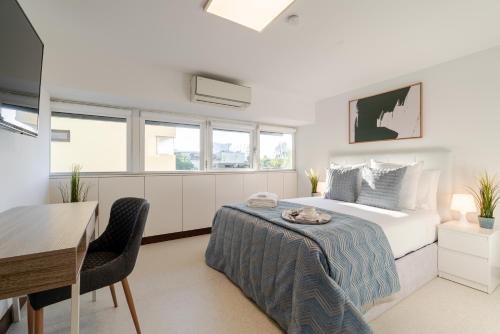a bedroom with a bed and a table and a desk at Bom Sucesso Executive Suites by HostWise in Porto