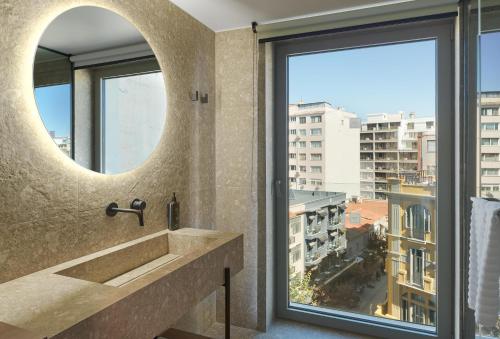 a bathroom with a sink and a large window at NYX Hotel Thessaloniki in Thessaloniki