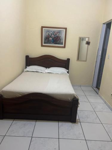a bed sitting in a room with a tiled floor at Recanto Mozão in Angra dos Reis