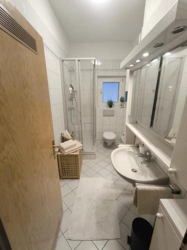 a bathroom with a sink and a shower and a toilet at Düsseldorf Apartment in Düsseldorf