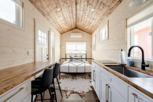 a kitchen with a sink and a bed in a room at Stay Portland - The Tiny Farmhouse on Alberta in Portland