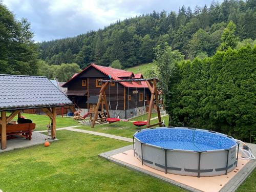 um quintal com um parque infantil e uma casa em VILLA MARTINI em Lazy pod Makytou