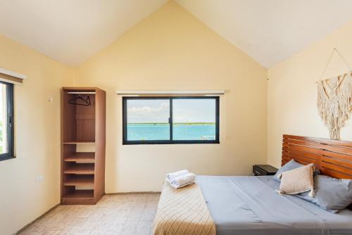 a bedroom with a large bed and a window at Casa Sirena - Habitaciones a orilla de la Laguna y Cenote Esmeralda in Bacalar