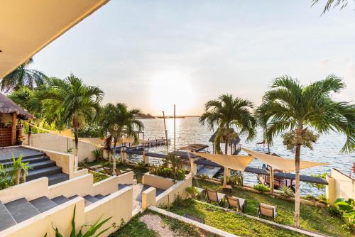 ein Resort mit Blick auf das Wasser und die Palmen in der Unterkunft Casa Sirena - Habitaciones a orilla de la Laguna y Cenote Esmeralda in Bacalar