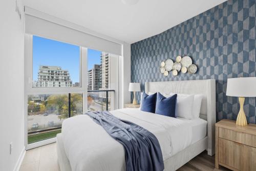 a bedroom with a large bed and a window at Modern West Getaway 2BR Condo with Free Parking in Toronto