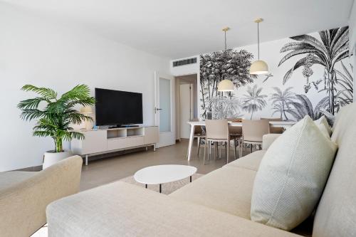 un soggiorno con divano e sala da pranzo di Hauzify I Apartaments Coral a Torredembarra