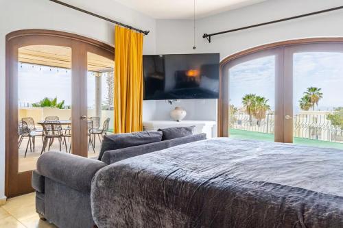 a bedroom with a bed and a couch and a balcony at Casa Reyes -All in One, Heated Pool & Beach Access in El Pueblito
