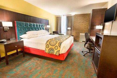 a hotel room with a bed and a desk at Heritage Inn & Suites San Antonio Airport, Trademark Wyndham in San Antonio