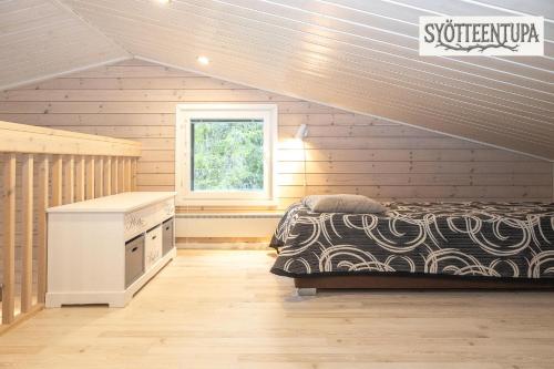 Un dormitorio con una cama en una habitación con paredes de madera. en Syötteentupa, en Syöte