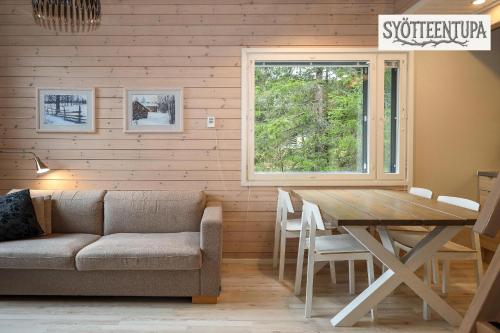 una sala de estar con una mesa y un sofá en Syötteentupa, en Syöte