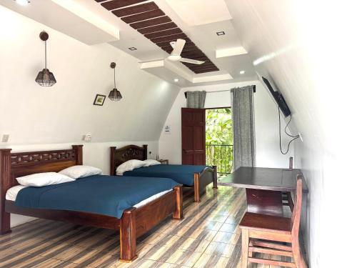 a bedroom with two beds and a table in it at Eco Hotel Villas del Tortuguero in Cariari