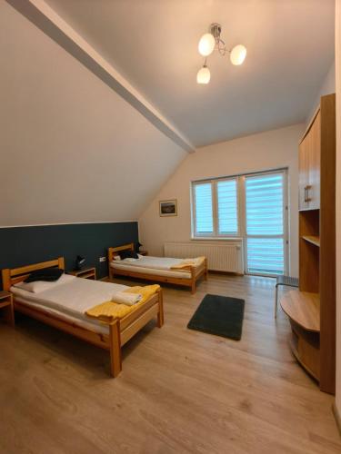 a bedroom with two beds and a large window at Apartamenty Starosądeckie in Stary Sącz