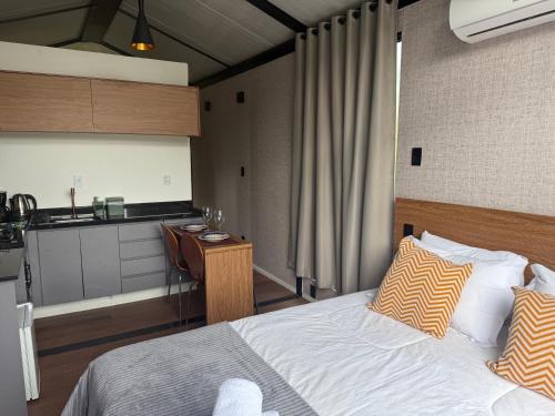 une chambre avec un lit et une petite cuisine dans l'établissement Monakó Cabanas, à Bragança Paulista