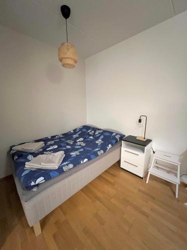 a bedroom with a bed and a nightstand and a lamp at Studio next to Sello and Leppävaara train station in Espoo