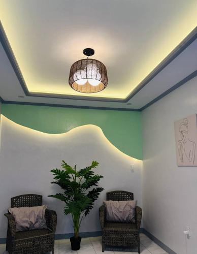 una habitación con 2 sillas y una maceta en CJ Hideaway, en Moalboal