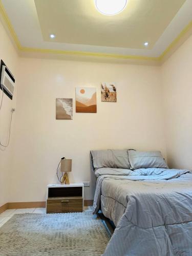 Un dormitorio con una cama y una mesa con una lámpara. en CJ Hideaway, en Moalboal