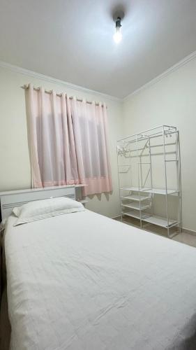 a bedroom with a white bed and a window at Casa em Santo André -SP in Santo André