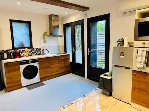 een keuken met een koelkast en een fornuis bovenste oven bij Duplex Montmorency à 30min de Paris in Montmorency