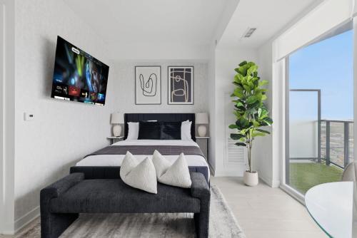 a bedroom with a bed and a tv on the wall at Skyline Studio with Stunning City Views & Parking in Toronto