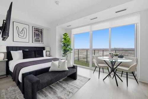 a bedroom with a bed and a table and chairs at Skyline Studio with Stunning City Views & Parking in Toronto