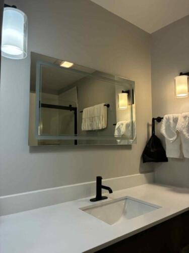 a bathroom with a sink and a mirror at The Bridges Hotel in Natchez