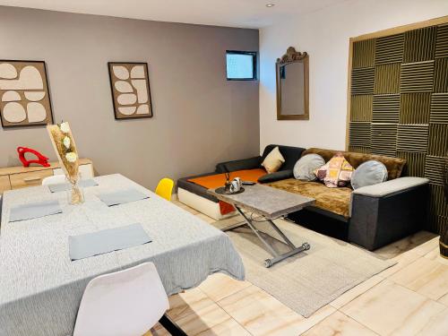 een woonkamer met een bank en een tafel bij Duplex Montmorency à 30min de Paris in Montmorency