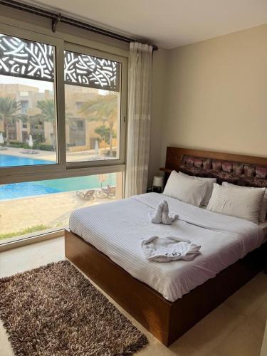 a bedroom with a bed and a large window at Mangrove M1-5B-13 in Hurghada