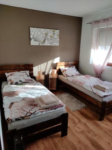 Un dormitorio con dos camas individuales y una ventana. en Apartman Lipa- Lipovac Bajakovo, en Lipovac