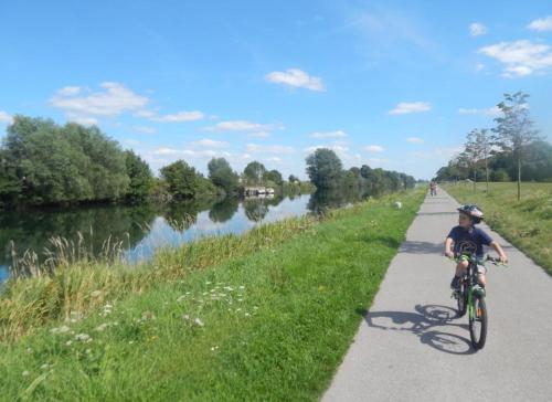 a boy riding a bike on a path next to a river at Le bon coin en Baie de Somme in Boismont