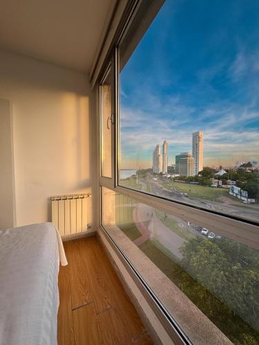 um quarto com uma grande janela com vista para o oceano em Puerto Norte em Rosário