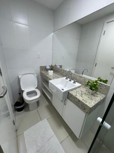 a white bathroom with a toilet and a sink at PACIFIC - PRAIA DO FORTE in Cabo Frio