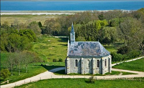 a small church in a field next to the ocean at Le bon coin en Baie de Somme in Boismont