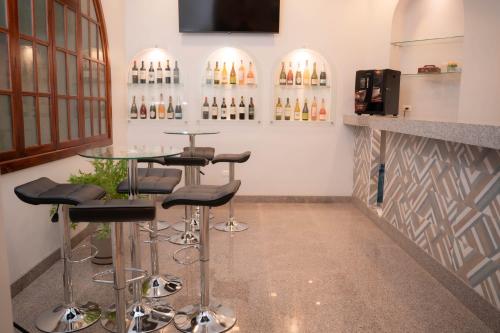 a bar with stools and a table in a room at Hotel Boutique Circasiana Palace in Quito