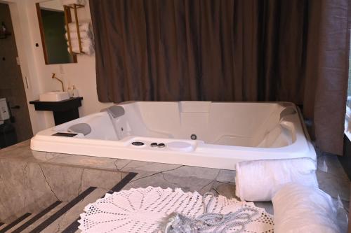 a white bath tub sitting in a bathroom at Cabana Horizonte Azul com Hidro e Churrasqueira in Santa Rosa