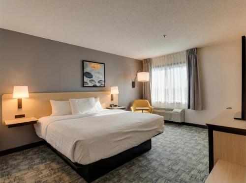 ein Hotelzimmer mit einem großen Bett und einem Fenster in der Unterkunft Hotel Bemidji in Bemidji