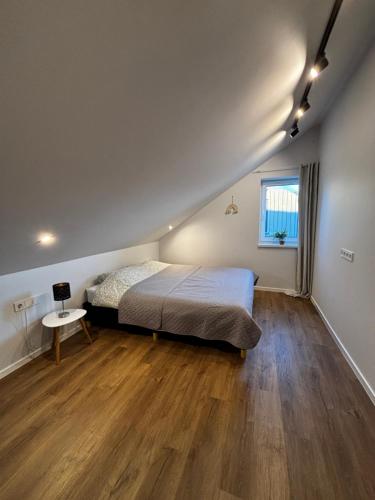 a bedroom with a bed and a wooden floor at Jūros namai in Palanga