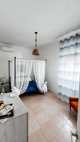 a room with a bed with a white curtain at Suite ad maiora in Torre Ovo