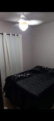 a bedroom with a black bed and a light at HosteldaRo in Penha
