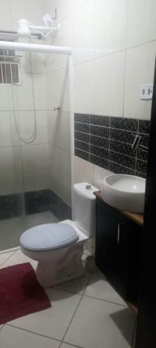 a bathroom with a toilet and a sink at HosteldaRo in Penha