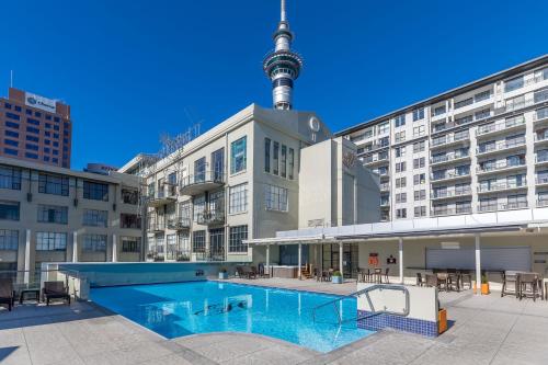 a swimming pool with the tv tower in the background at Deluxe Heritage - Roof Top Pool & Gym near Sky Tower in Auckland