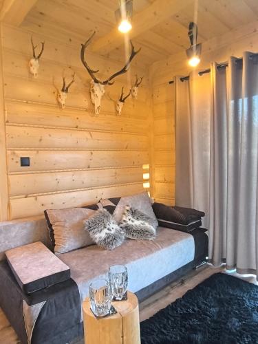 a living room with a couch and antlers on the wall at Domek Góralsko Gawra in Murzasichle