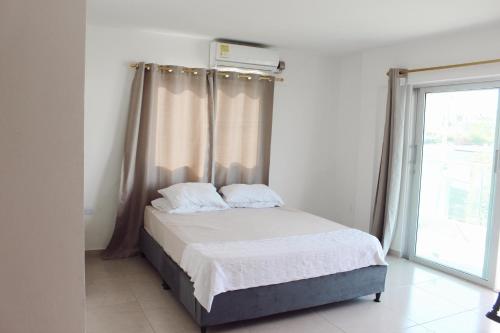 a bedroom with a bed with curtains and a window at Cabaña Sisiguaca in Santa Marta