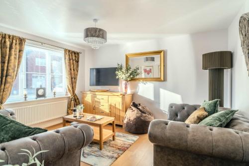 a living room with two couches and a tv at Spacious Cotswolds Base, Private Garden & Parking in Evesham