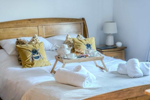 a bedroom with a bed with a tray with tea sets on it at Modern 3-Bed in Historic Evesham & Garden in Evesham