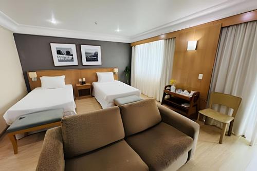a living room with two beds and a couch at Mediterrâneo Flat in Rio de Janeiro