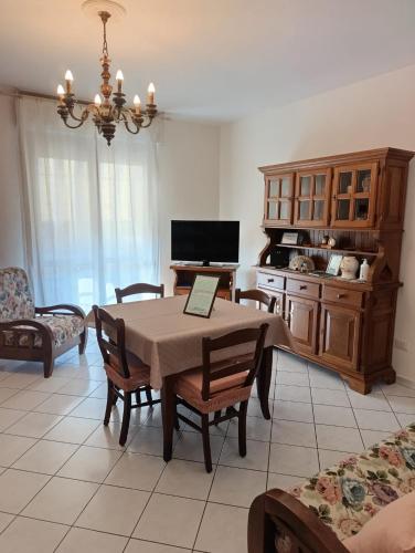 ein Wohnzimmer mit Tisch und Stühlen und eine Küche in der Unterkunft Book Nook Pisa, circa 10 minuti da Pisa, vicino all'Ospedale di Cisanello e all'Aeroporto, parcheggio privato a disposizione in Cascina